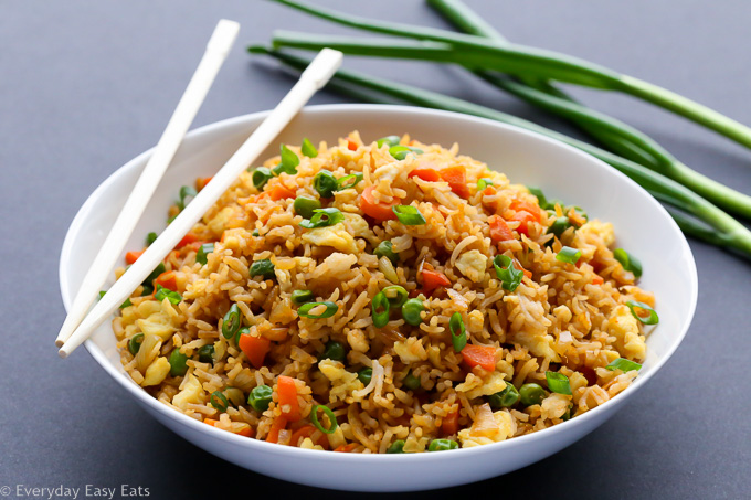 Side view of Chinese Fried Rice in a white plate on a dark background.