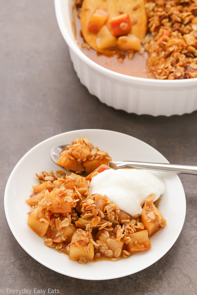 Close-up overhead view of a plate Gluten-Free Apple Crisp topped with whipped cream.