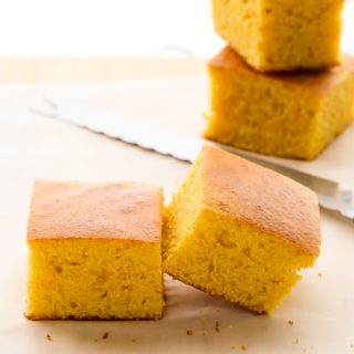 Side view of sliced Cornbread Without Buttermilk on a wooden chopping board.