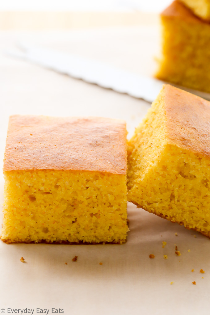 Close-up side view of sliced Cornbread Recipe Without Buttermilk on a wooden chopping board.