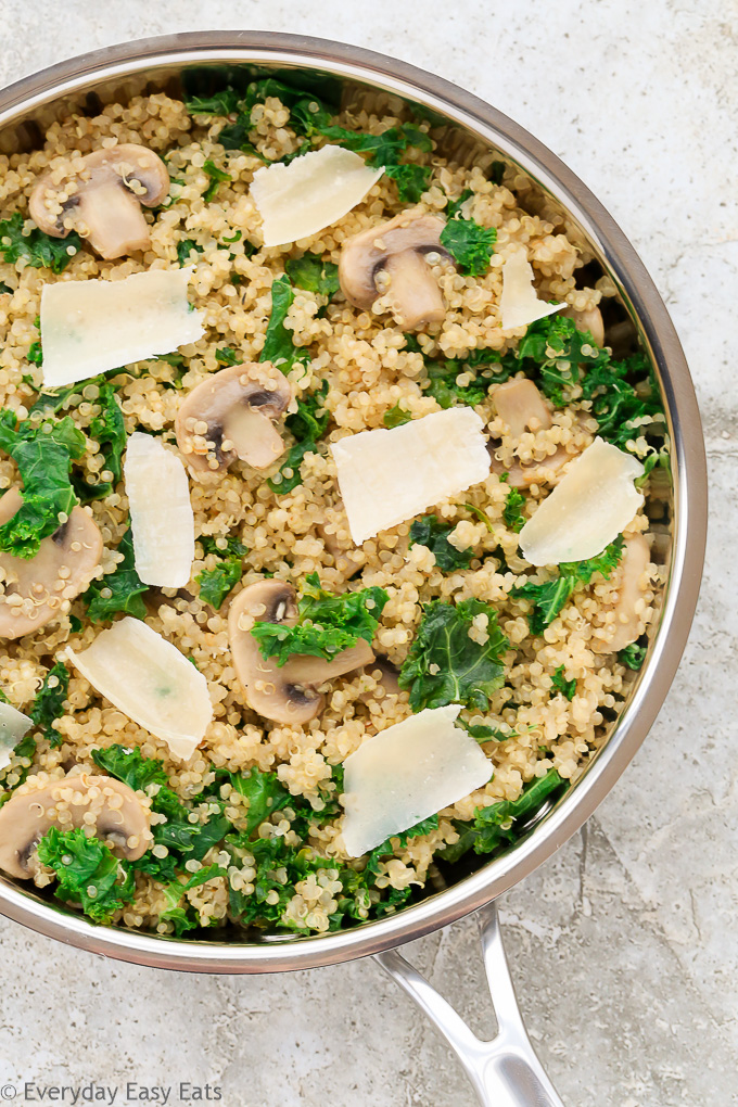 Budget-Friendly Meals: Close-up overhead view of Mushroom Kale Quinoa in a skillet on a neutral background.