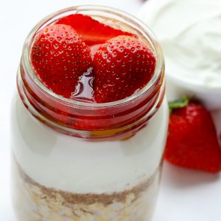 Overhead view of Strawberry Overnight Oats with Yogurt in a mason jar on a white background.