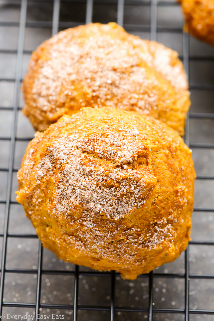 Overhead view Pumpkin Spice Cake Cookies on a wire cooling rack on a dark background.