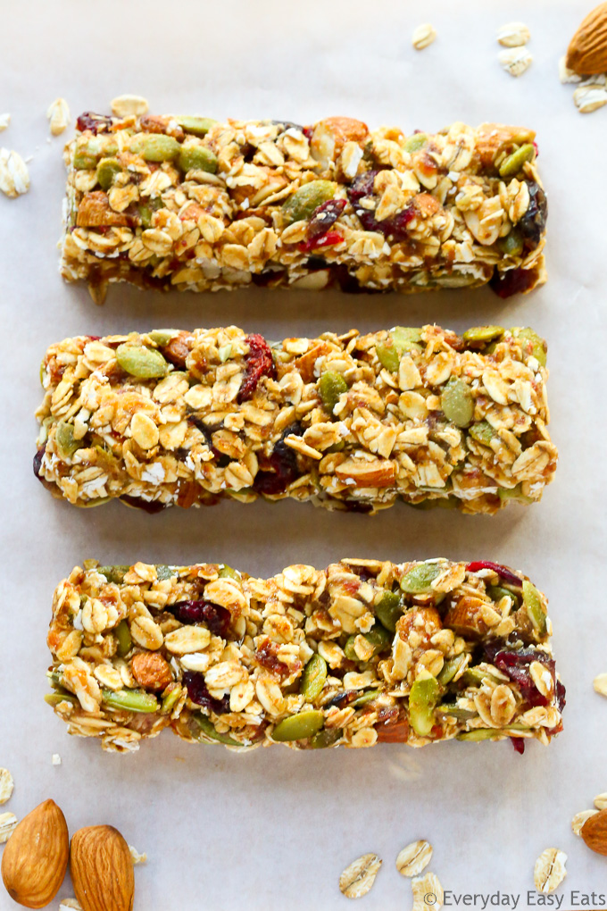 Close-up overhead view of three No-Bake Healthy Fruit and Nut Granola Bars on a white background.