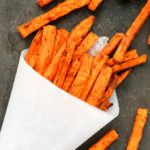 Overhead view of Spicy Baked Sweet Potato Fries against a dark background.