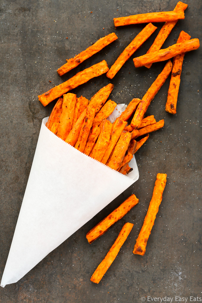 Overhead view of Oven-Baked Sweet Potato Fries Without Cornstarch on a dark background.