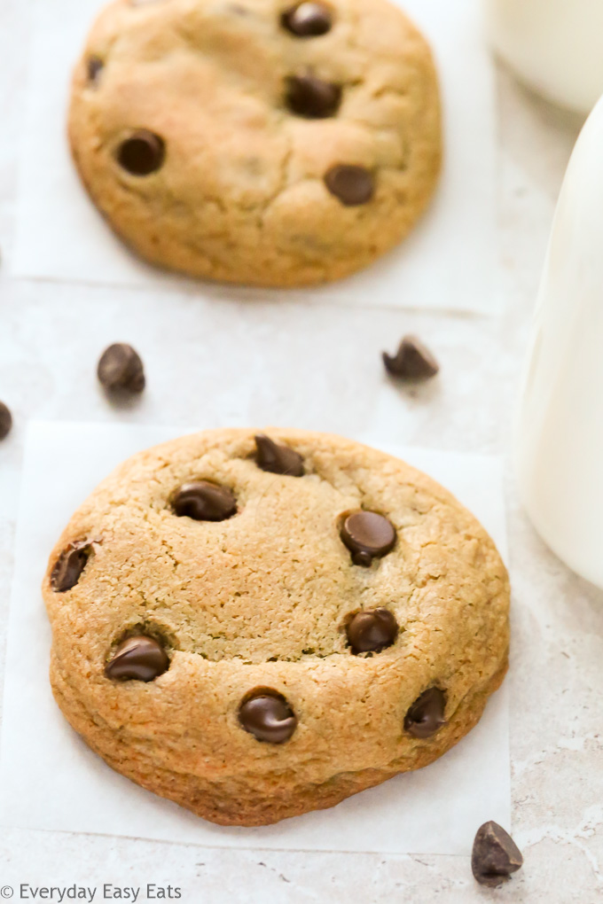 Close-up overhead view of No-Chill Chocolate Chip Cookies with Cornstarch  with scattered chocolate chips on a neutral background.