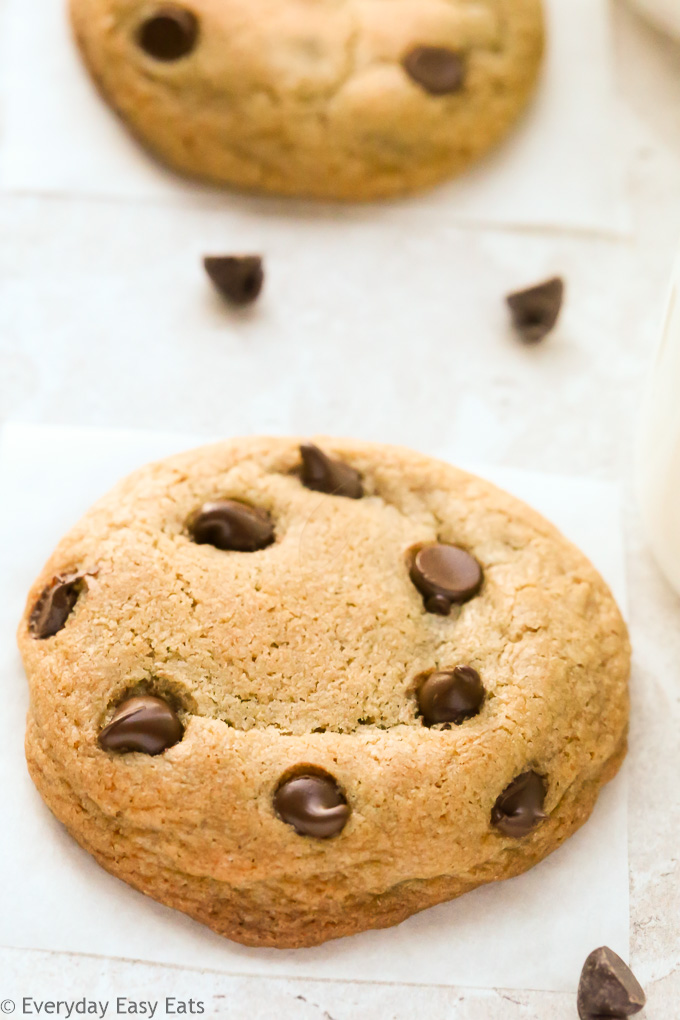 Close-up overhead view of No-Chill Chocolate Chip Cookies with Cornstarch with scattered chocolate chips on a neutral background.