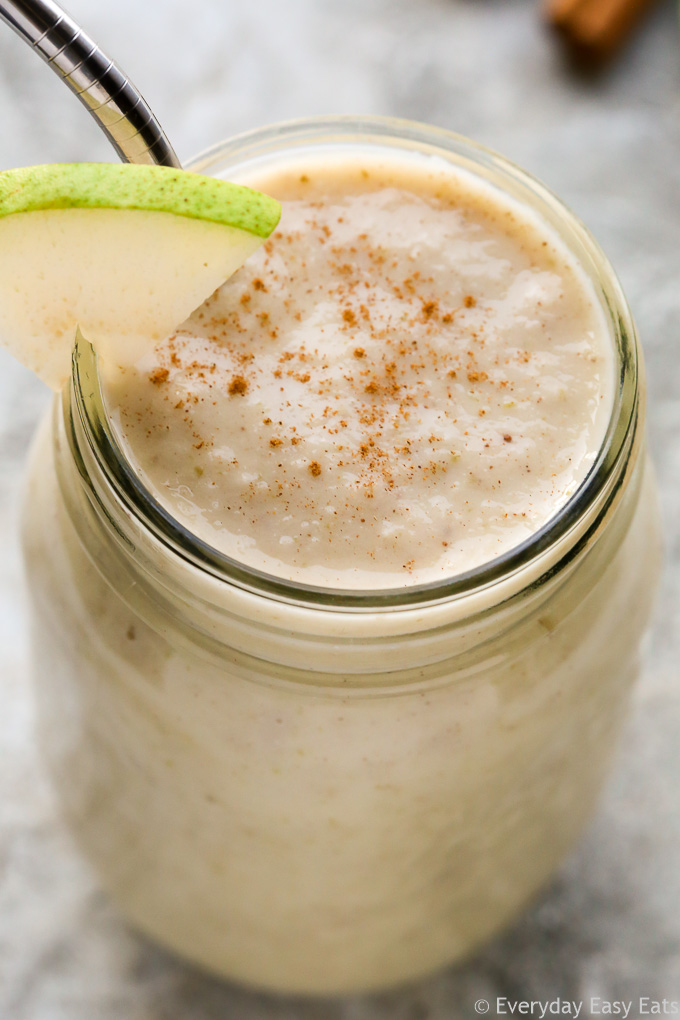 Close-up overhead view of a Pear Smoothie in a mason jar on a grey background.