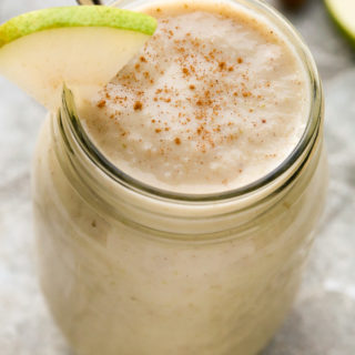 Overhead view of a Spiced Pear Smoothie in a mason jar on a grey background.
