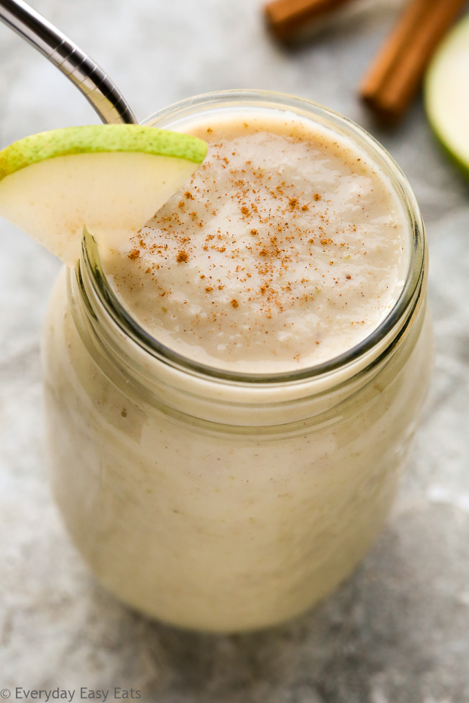 Overhead view of a Spiced Pear Smoothie in a mason jar on a grey background.