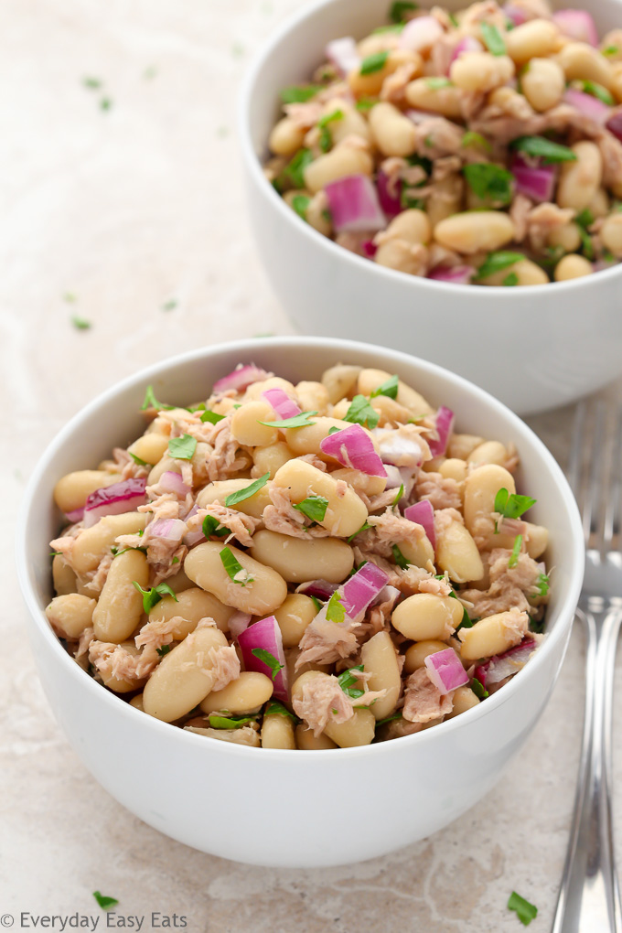 Budget-Friendly Meals: Close-up side overhead view of two bowls of Tuna White Bean Salad on a neutral background.