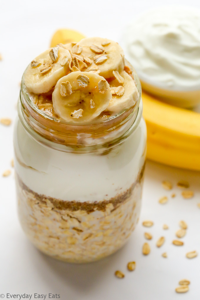 Overhead view of Peanut Butter Banana Overnight Oats in a mason jar against a white background.