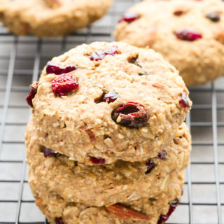 Side view of Peanut Butter Banana Oatmeal Cookies in a stack on a wire cooling rack set on a dark background.