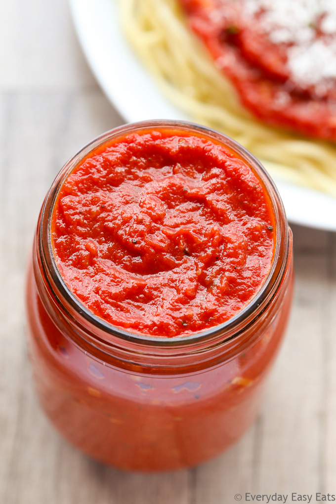Overhead view of Quick Marinara Sauce in a jar with a plate of pasta in the background