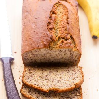 Overhead view of a sliced loaf of Best-Ever Moist Banana Bread on a wooden chopping board.
