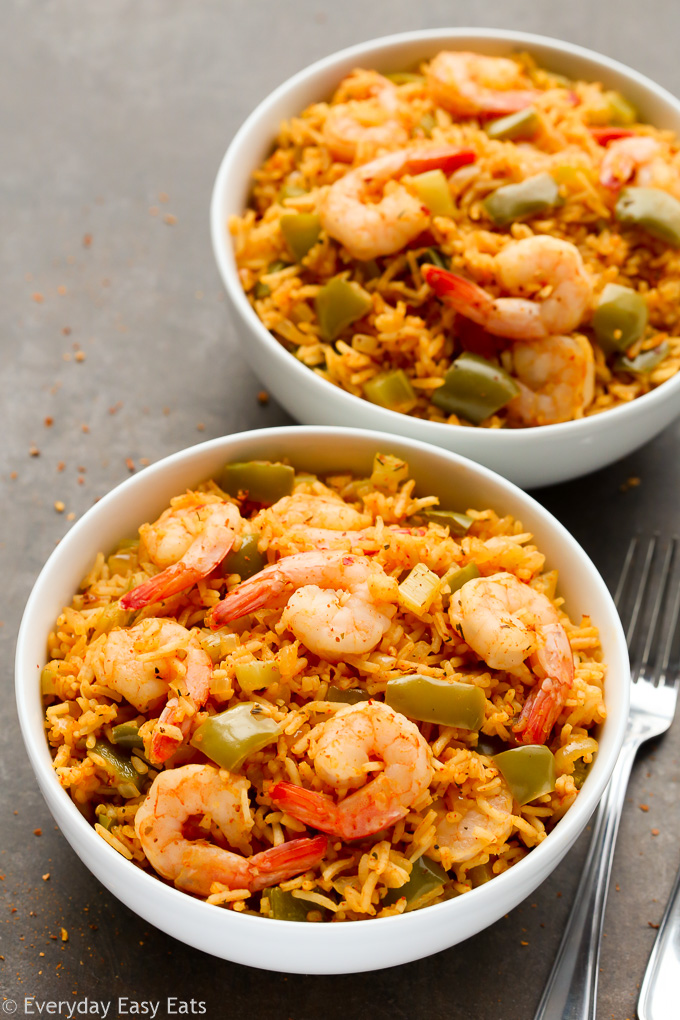 Overhead view of two bowls of One-Pan Cajun Shrimp and Rice on a dark background.