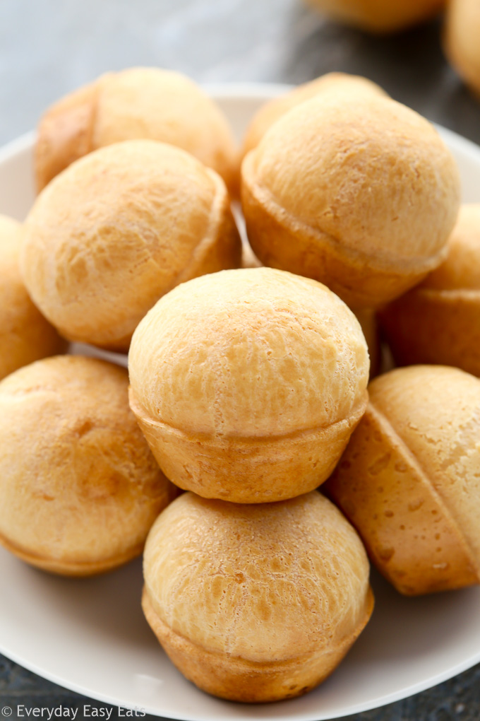 Side view of Brazilian Cheese Bread (Pão de Queijo) in a white plate.