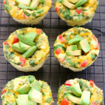 Overhead view of Breakfast Egg Muffins cooling a on wire rack set above a dark background.