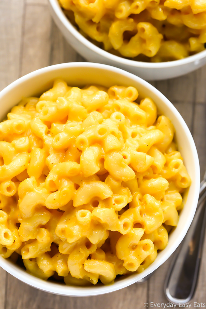 Close-up overhead view of a bowl of Creamy Homemade Macaroni and Cheese on a wooden background.