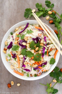 Overhead view of a bowl of Thai Noodle Salad with Coconut-Lime Dressing with chopsticks on a grey background.