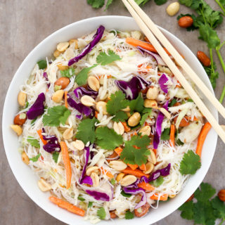 Overhead view of a bowl of Thai Noodle Salad with Coconut-Lime Dressing with chopsticks on a grey background.