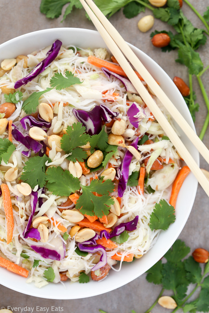 Close-up overhead view of a bowl of Thai Noodle Salad with Coconut-Lime Dressing with chopsticks on a grey background.