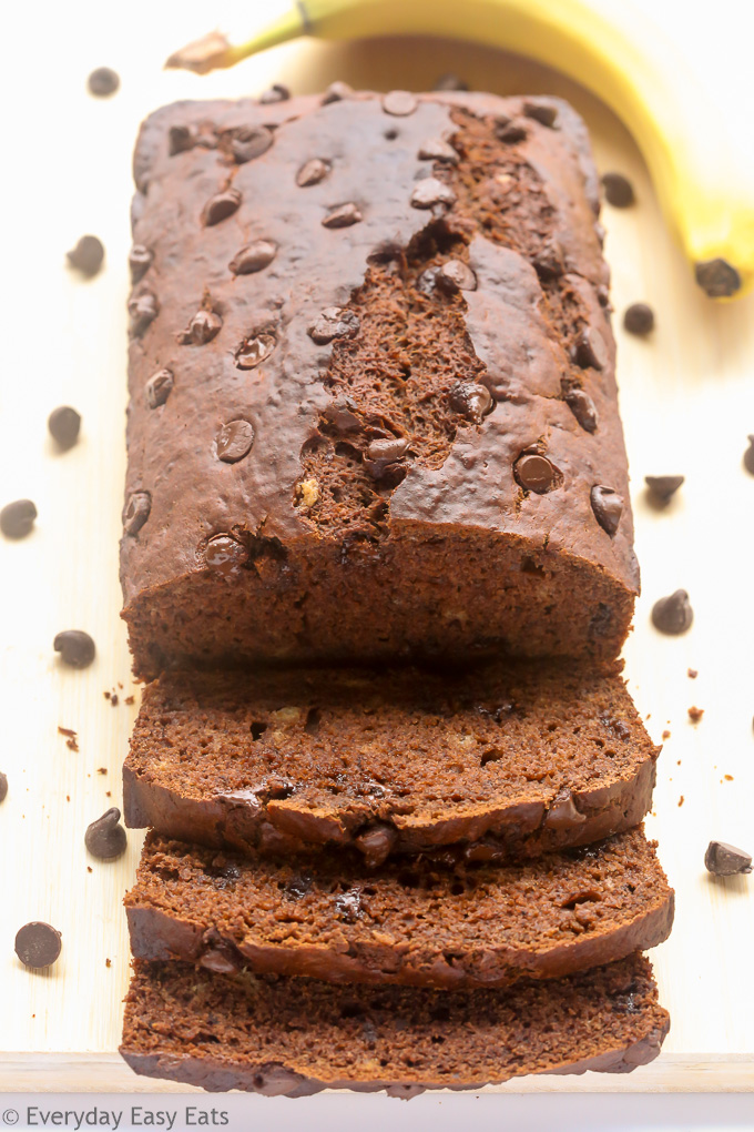 Overhead view of a sliced loaf of Double Chocolate Banana Bread on a wooden chopping board.