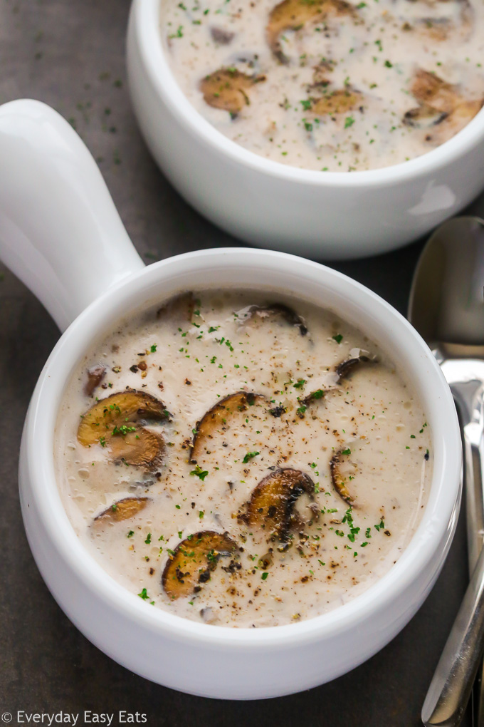 Close-up overhead view of a bowl of Cream of Mushroom Soup on a dark background.