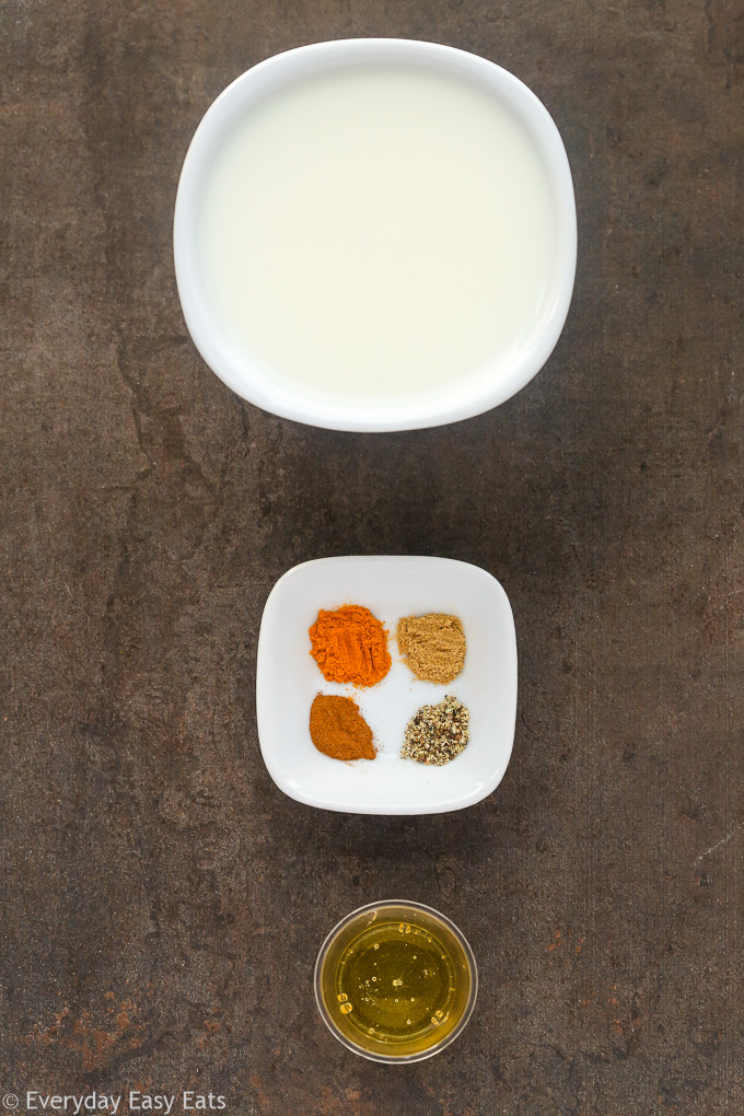 Overhead view of Golden Latte (Turmeric Milk) ingredients on a dark surface.