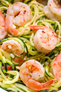 Zoomed-in view of Zucchini Noodles with Garlic Shrimp in white bowls on a black background.
