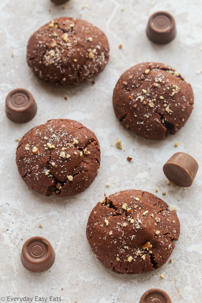 Overhead view of Chocolate Rolo Cookies with scattered Rolo candies on a neutral background.