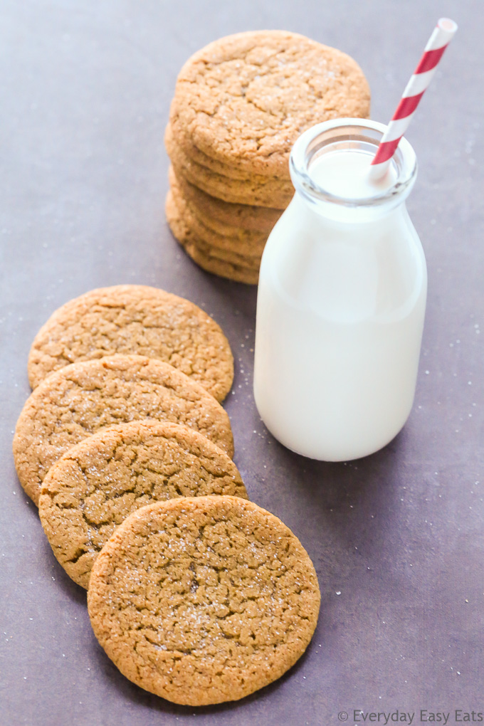 Overhead view of Molasses Cookies Without Shortening with a glass of milk on a dark background.