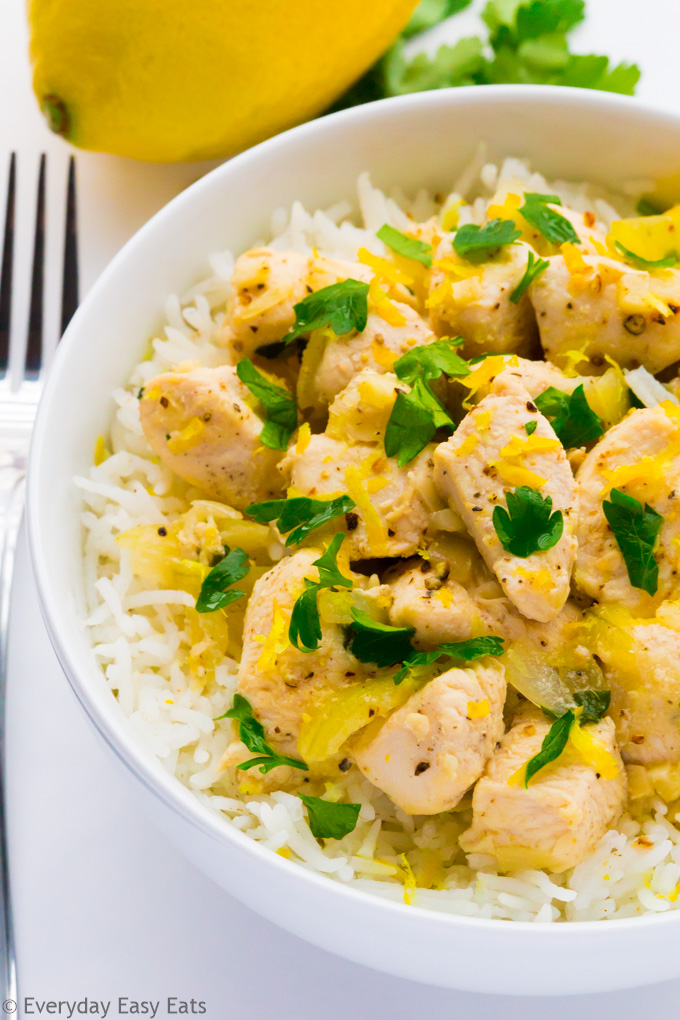 Close-up overhead view of Chicken Scampi Without Wine in a white bowl on a white background.