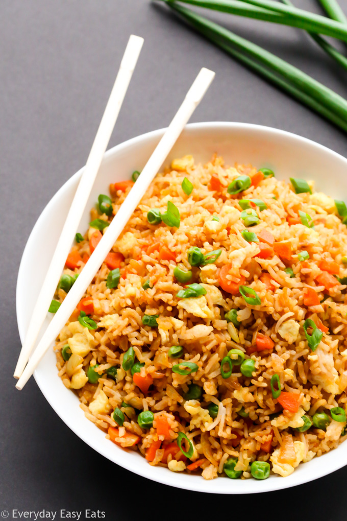 Easy Asian Rice Recipes for Dinner: Overhead view of Chinese Fried Rice in a bowl with chopsticks on a dark background.