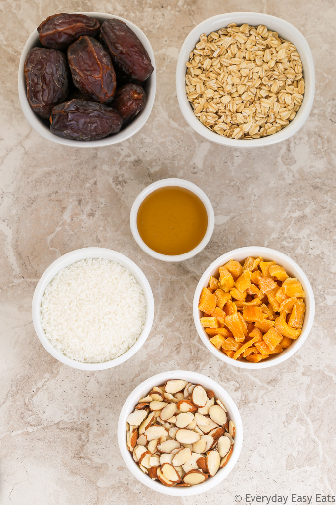 Overhead view of ingredients for Healthy Mango Coconut Granola Bars in white bowls