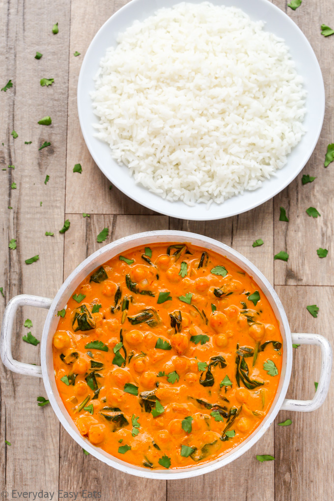 Overhead view of Indian Coconut Chickpea Curry in a silver serving bowl with a plate of white rice 