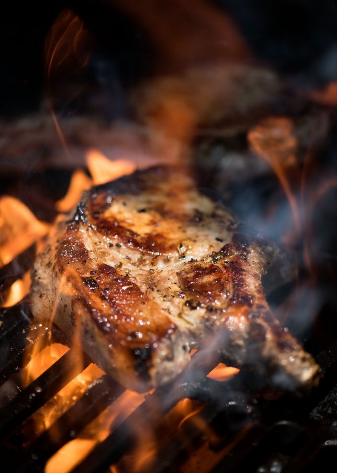 Healthy Grilled Meat Recipes for Summer: Side view of Lemon Garlic Marinated Grilled Pork Chops on a barbeque.
