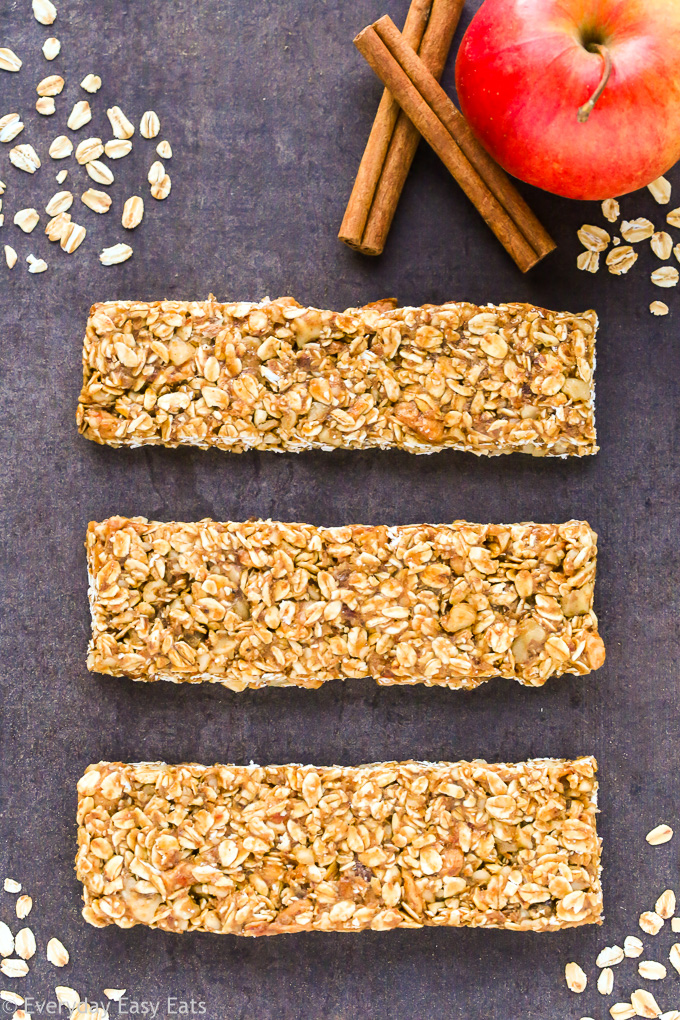 Overhead view of three Healthy Apple Cinnamon Granola Bars on a dark background.