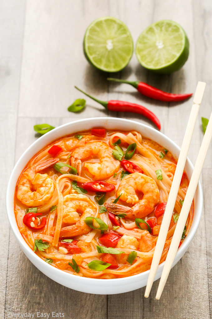 Side overhead view of Thai Shrimp Soup with Noodles in a white bowl with chopsticks on a wooden background.