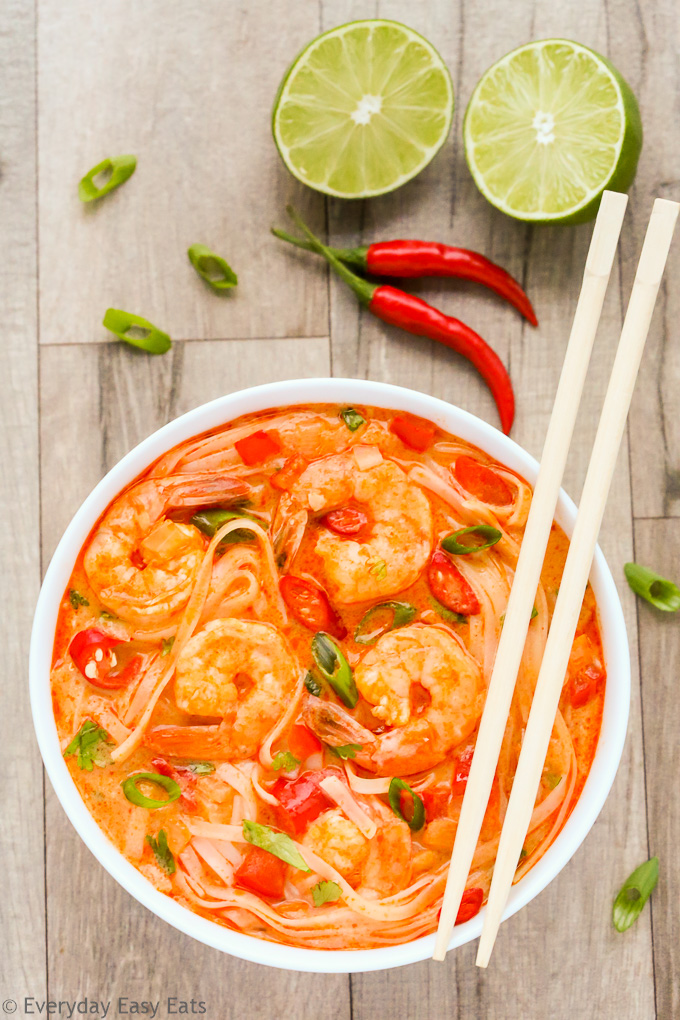 Overhead view of Thai Shrimp Soup with Noodles in a white bowl with chopsticks on a wooden background.