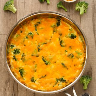 Overhead view of Broccoli Cheese Frittata in a skillet on a wooden background.