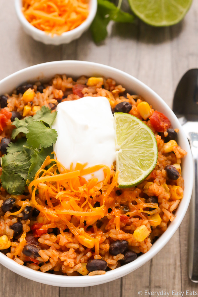 Close-up overhead view of Burrito Rice in a white bowl on a wooden background.