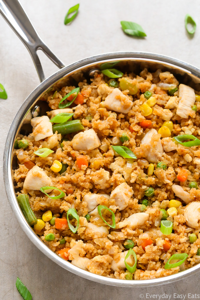 Close-up overhead view of a skillet of Healthy Chicken Fried Rice on a neutral background.