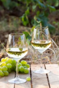 Natural Wine Delivery: Glasses of white wine with green grapes on the side