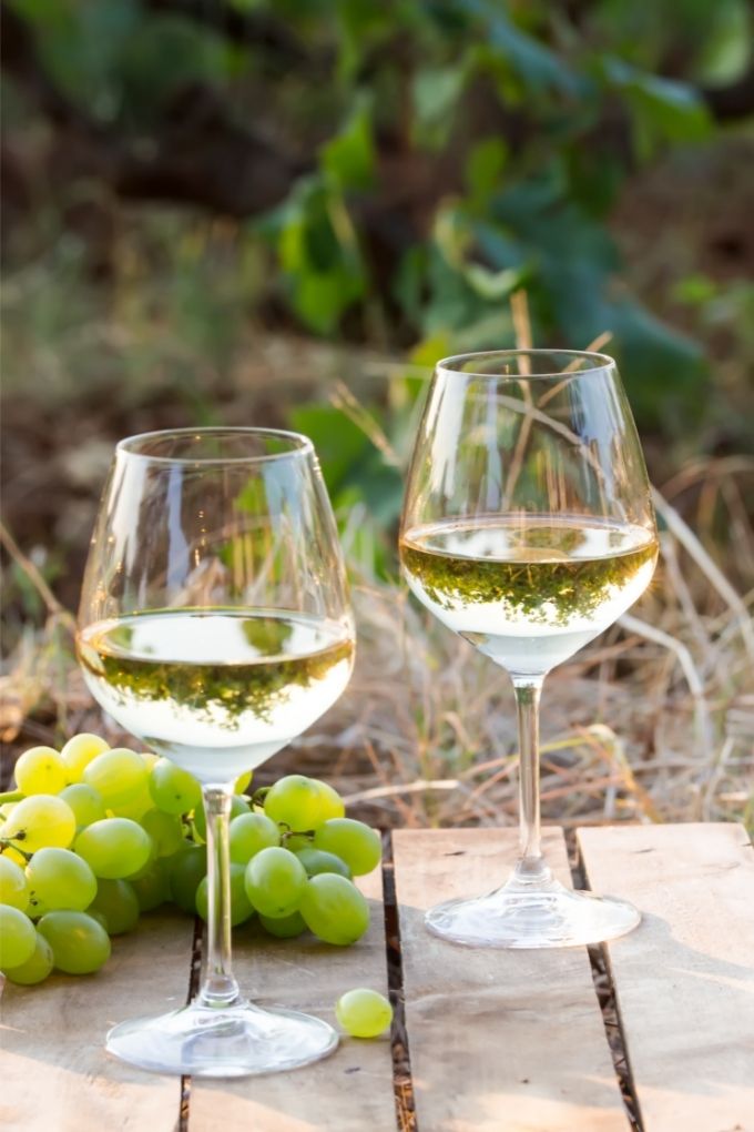 Organic Wine Delivery Services: Glasses of white wine with green grapes on the side