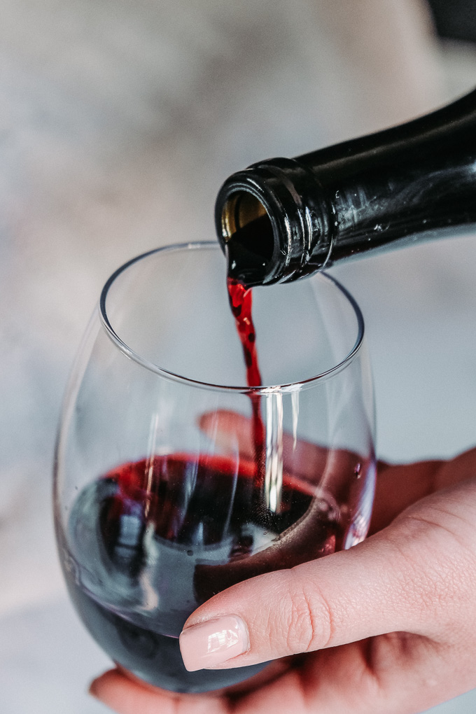 Woman pouring red wine into a glass