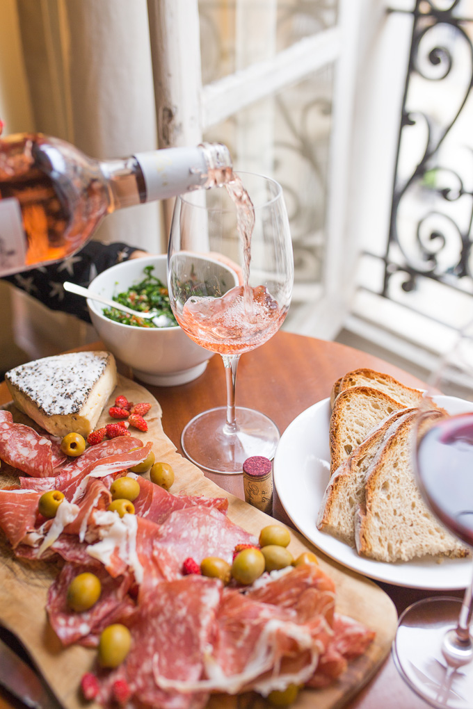 Sustainable Online Wine Stores: Rosé wine being poured into a glass on a table with food