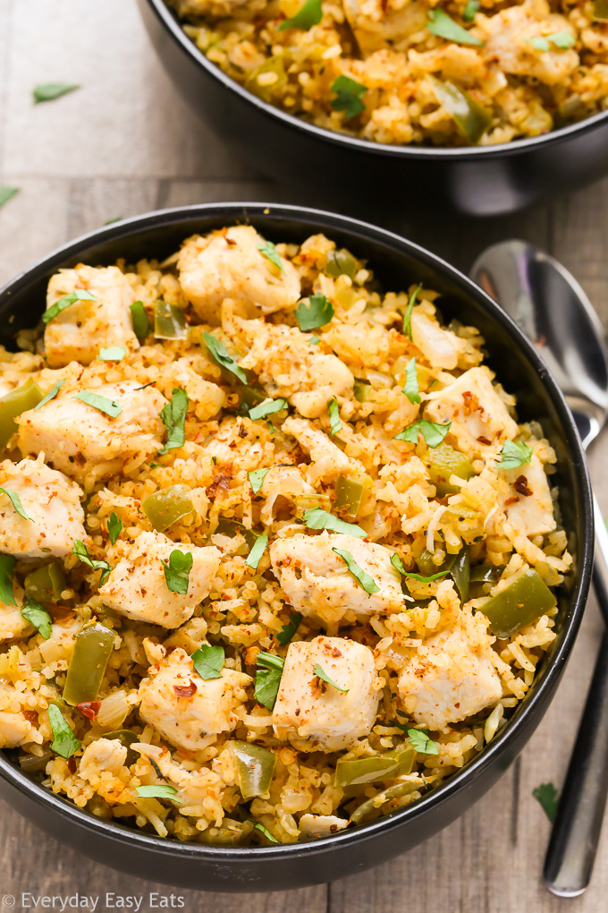 Close-up overhead view of a bowl of Cajun Chicken and Rice on a beige background.