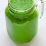 Side overhead view of a Green Protein Smoothie in a glass jar on a white background with title text overlay.